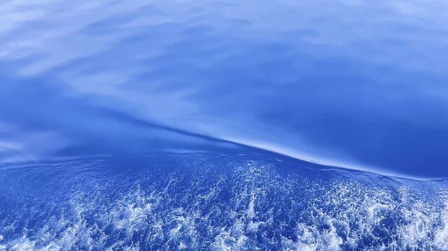 Wind ripples and boat wake patterns on blue tropical water near Coron Palawan Philippines with foam texture and open sea surface seen from a moving vessel