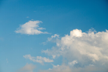 Fototapeta premium Bright blue sky filled with fluffy white clouds, often used as a natural backdrop. clear blue sky alongside scattered white cumulus clouds.