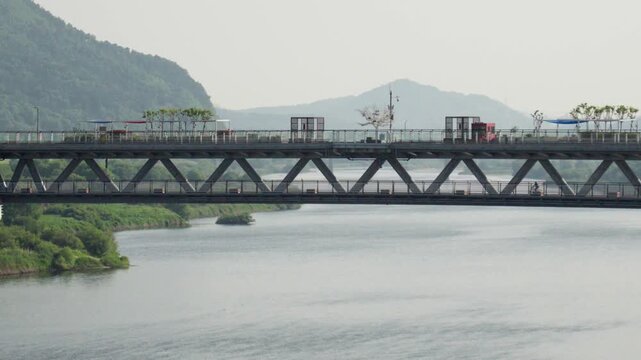 Side Profile of Eungdari Double-Deck Bridge over Geumgang River with a Person Cycling
