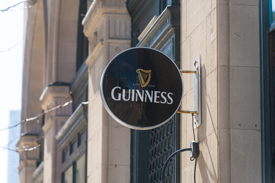 Toronto, Canada - April 17, 2026: Energetic downtown street in Toronto emphasizing traditional pub signs and enduring