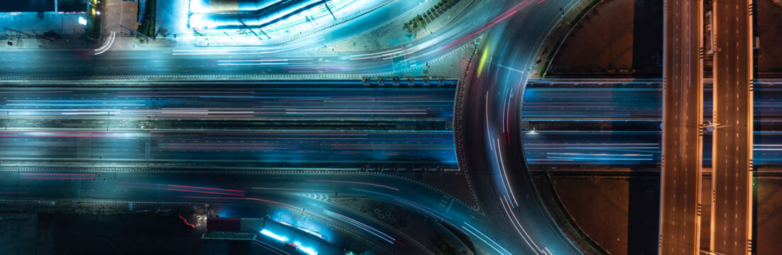 Abstract aerial highway scene with colorful motion blur traffic and modern infrastructure, ideal for smart city, ESG investment, sustainable mobility, and commercial backgrounds.