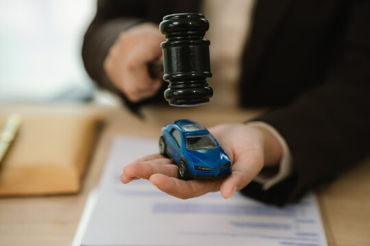 Judge&rsquo;s gavel above a model car, symbolizing auto insurance claims, legal disputes, vehicle liability, compensation, and transportation law.