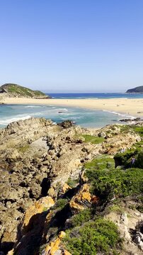 Hikers on Robberg hiking trail going toward beach at The Island. Vertical