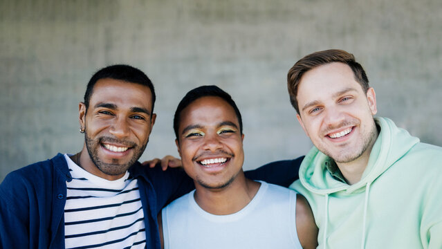 Happy diverse male friends having fun outdoors - Lgbt community and pride month event concept