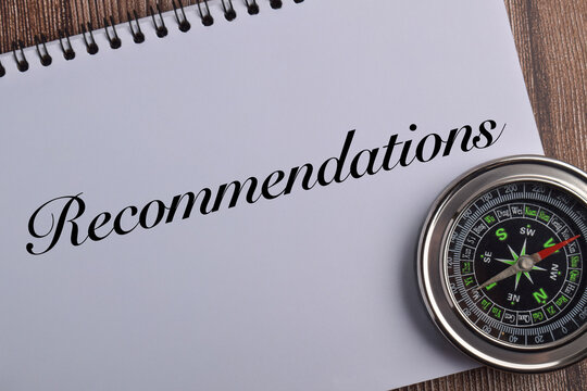 Recommendations concept with compass and notebook on wooden background representing guidance, advice, consultation, strategic direction, planning, and professional support.