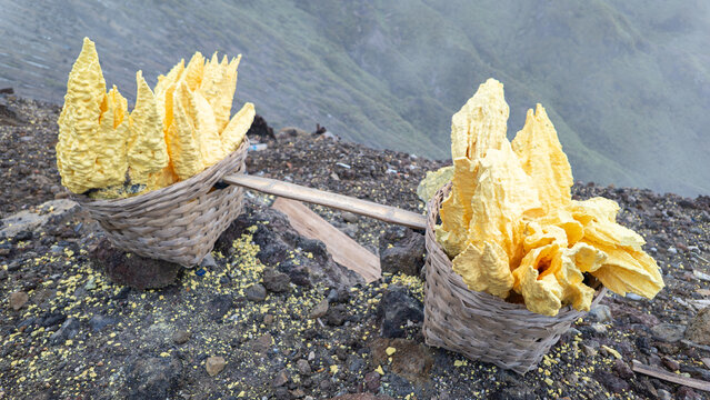 Freshly mined sulfur blocks collected by miners at the Ijen Crater in Banyuwangi, East Java, Indonesia. Sulfur is a natural mineral formed by volcanic activity. Concept of sulfur mining, geology.