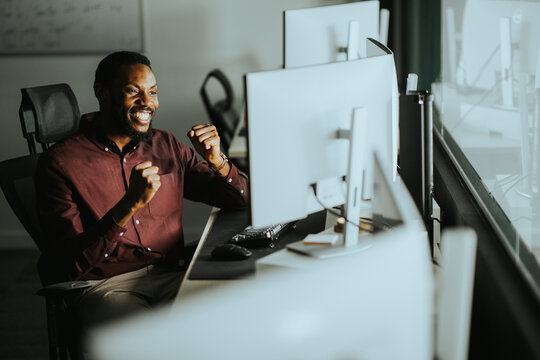 Person in office enjoys success while using computer at work during the day