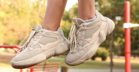 Naklejka premium Woman in white sneakers on sport ground, closeup
