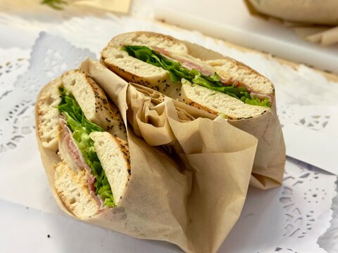 Bagel sandwich wrapped in brown paper, ready for a grab and go lunch