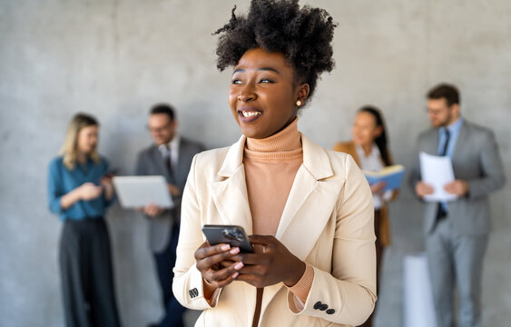 In a modern office, a successful businesswoman multitasks with phone communication