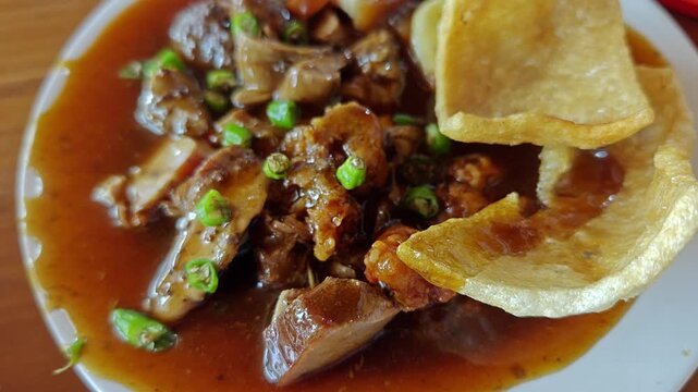 Traditional Balinese Siobak Pork Dish with Thick Gravy and Crackers