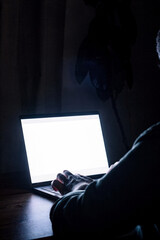 Naklejka premium Person typing on laptop in dim light at home during late night hours