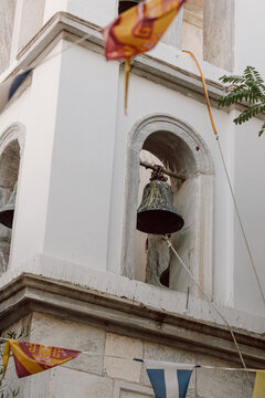 Old bell tower with flags in Greece traditional architecture