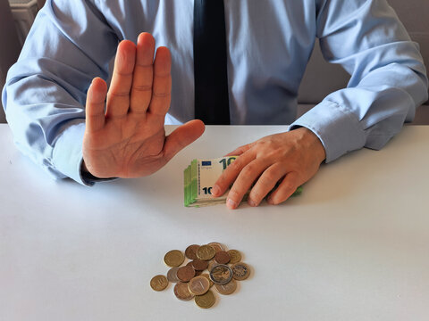 A stack of 100 Euro banknotes and scattered Euro cent coins are on a white table. Concept of financial planning, budgeting, savings, or business transactions. Bright minimalistic background.