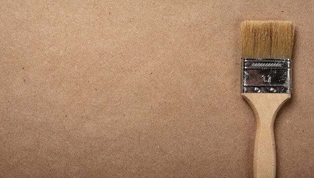 Paint brush wooden handle metallic ferrule fiber bristles hardboard surface horizontal framing