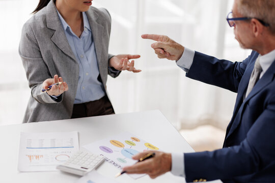 Business people engaging in a heated workplace disagreement. Discussing problem issues and conflict management strategies during a stressful office meeting