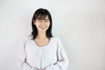 Fototapeta premium Young Asian woman smiling at camera against white background