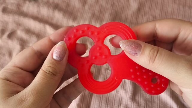 Red Soft Rubber Teether For Kids In Hands