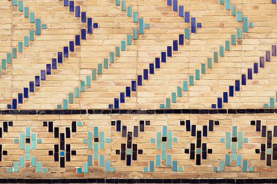 Glazed tile and brick wall detail of Bibi-Khanym Mosque in Samarkand showing geometric patterns. Ideal for architecture, travel, and cultural heritage publications. Tiles texture, pattern, background.