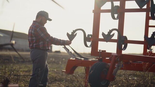 Rural life and farming, agronomist reading instruction for tractor in smartphone . Phone addiction, mobile gadget overuse, modern technology for agribusiness and agriculture, villager in farmland