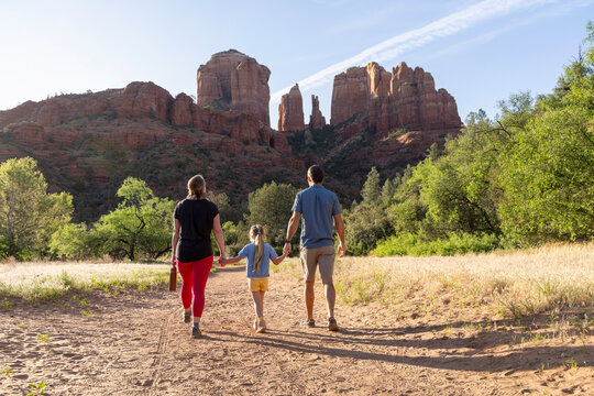 Family of three walking trail in mountain wilderness