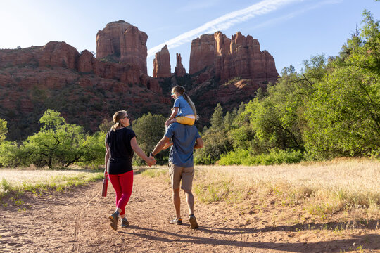 Family of three hiking outdoors mountainous trail