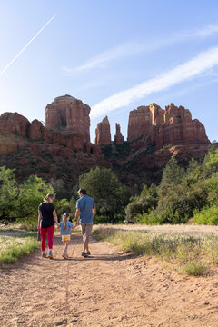 Family of three walking towards mountain view on wilderness trail