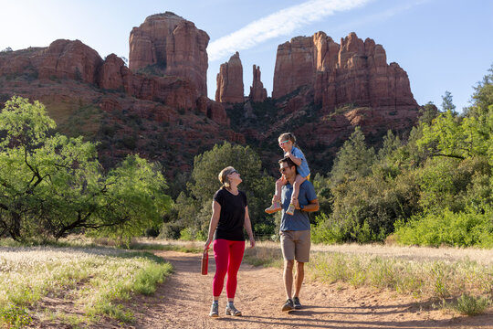 Family of three appraching on outdoor hiking trail with mountain view