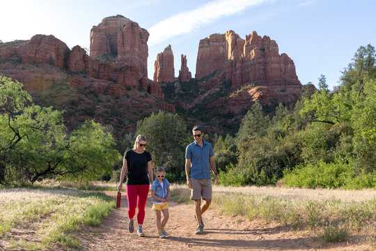 Family of three approaching on trail mountain background