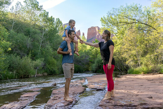 Family of three enjoying outdoors natural stream