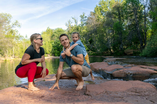 Family of three playing enjoying outdoors by creek