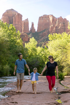 Family of three enjoying outdoors in wet rocky environment