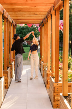 Young couple dancing under wooden pergola