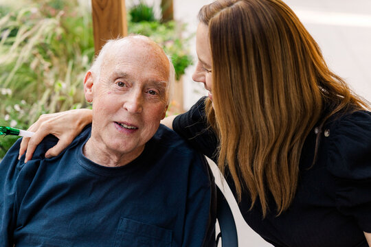 Senior man supported by caring woman outdoors