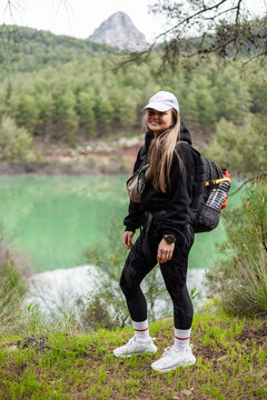 Smiling woman enjoying a mountain hike by a lake
