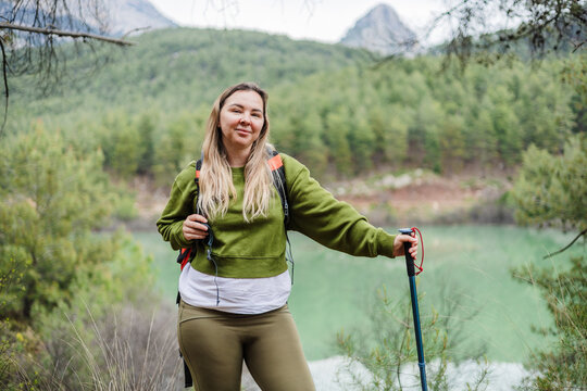 Smiling woman with backpack hiking in the mountains