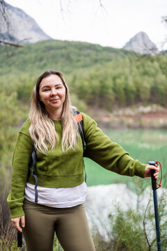 Happy woman hiking in the mountains with poles