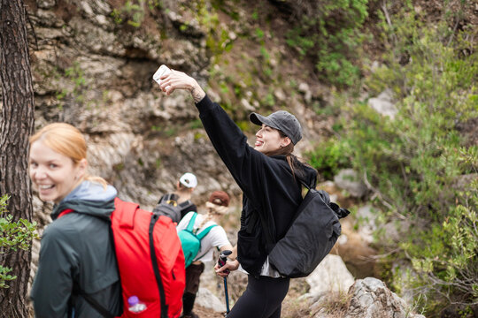 Young woman taking a hiking selfie with her friends
