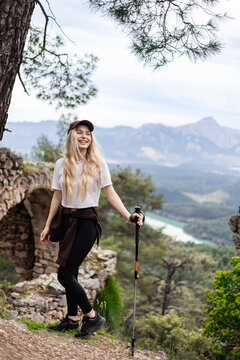 Happy young woman hiking on a scenic mountain trail