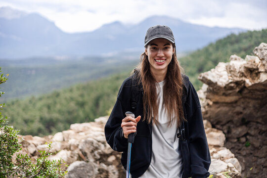 Happy young woman hiking on a scenic mountain trail