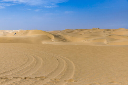 A 4x4 vehicle tackles massive desert sand dunes