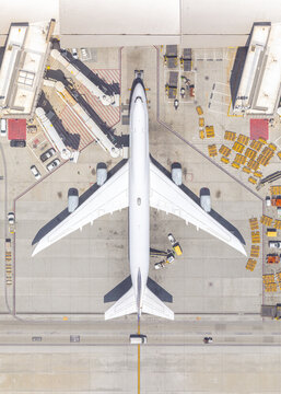 Aerial top down view of airplane at airport terminal