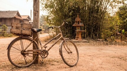 Obraz premium Vintage Bicycle Leaning Against a Pole in a Rural Village Scene.