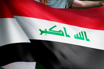 Naklejka premium Person holding Iraq flag background, national symbol