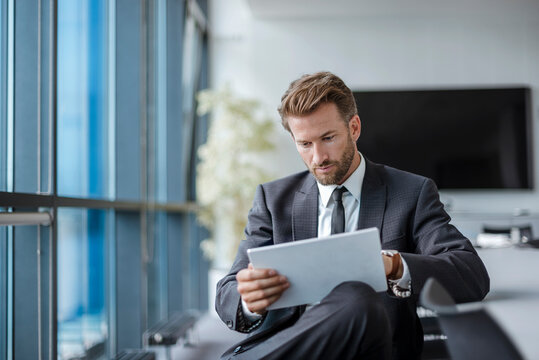 Businessman sitting in conference room using tablet
