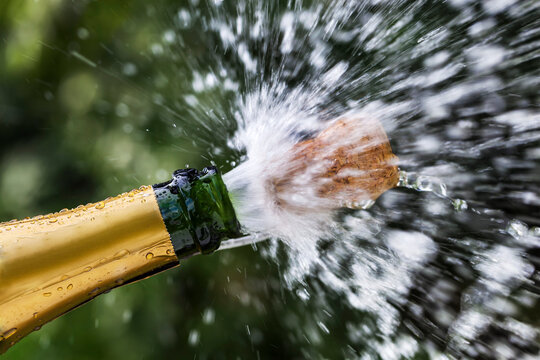 Opened champagne bottle with flying cork