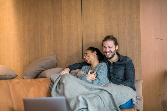 Laughing young couple relaxing together on the couch