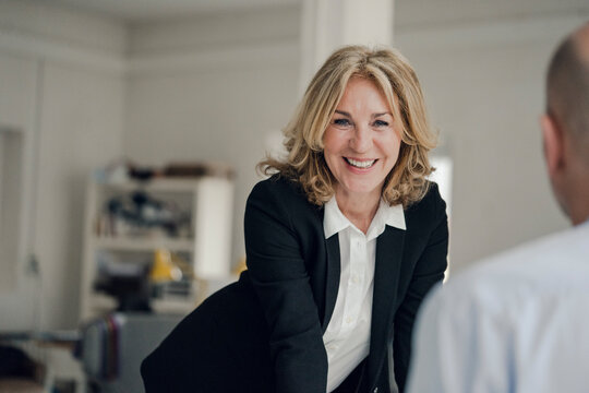 Smiling senior businesswoman looking at colleague