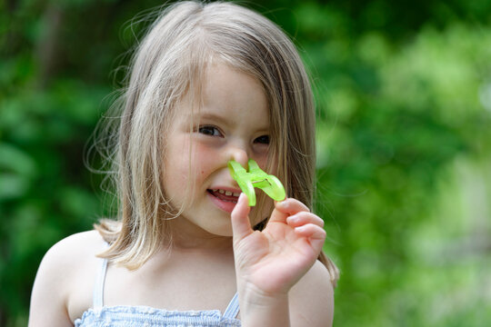 Portrait of little girl with clothes peg on her nose