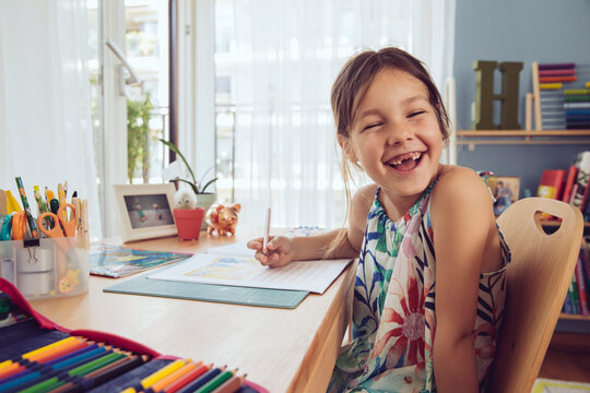 Happy girl doing her schoolwork at home